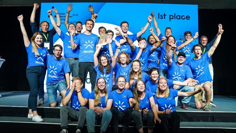 Die Gewinner des Solar Decathlon jubelnd, alle in blauen T-Shirts.