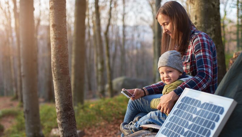 Frau und Kind nutzen Solarstrom fürs Handy.