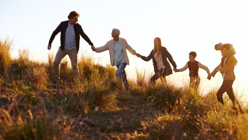 Symbolbild: Familie besteigt gemeinsam einen Hügel.